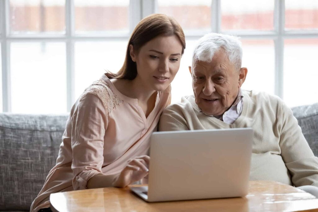 Adult daughter old father choose services via internet using computer
